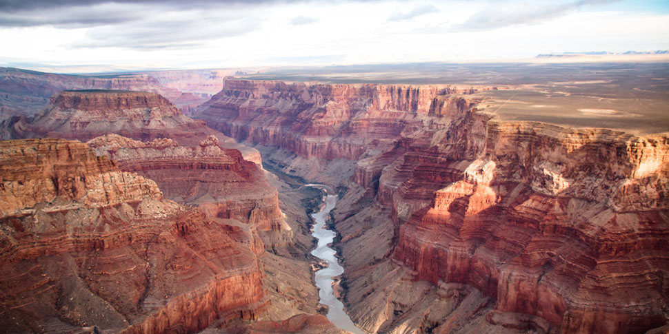 Scenic landscape of the Grand Canyon with a river winding through the canyon.
