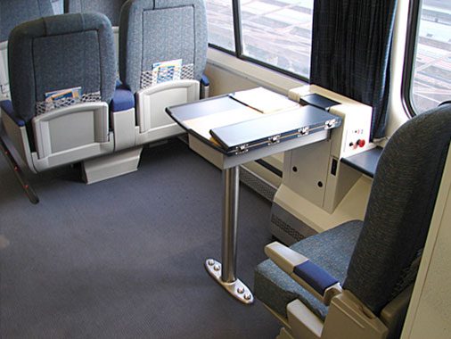 Accessible seat and wheelchair space with tray table open.
